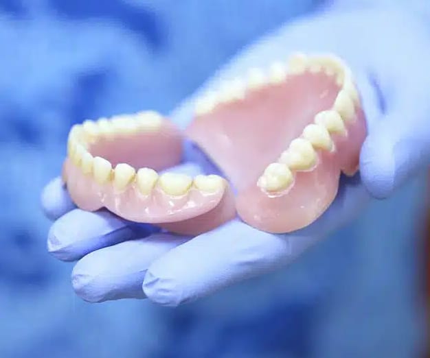 dentist holding full dentures in ventura